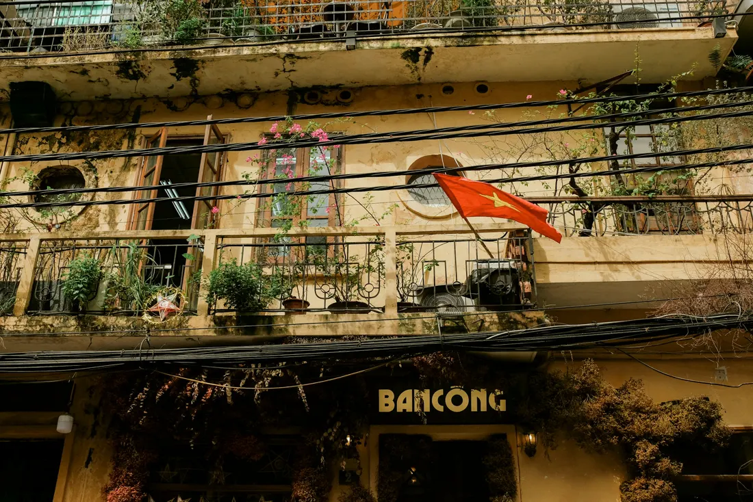 A Hanoi balcony with a red flag